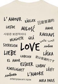 Felpa di cotone beige con la parola "LOVE" in nero, con traduzioni in diverse lingue disposte in vari font e dimensioni.