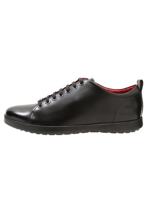 Baskets basses en cuir noir avec lacets noirs, finition lisse, doublure intérieure rouge et semelle en caoutchouc, vues de profil.
