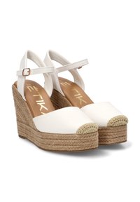 Sandalias de esparto con cuña blanca, correas en el tobillo, suelas de plataforma trenzada de yute y punteras cerradas con detalles tejidas.