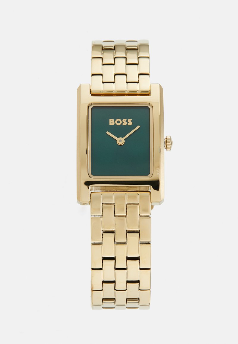 Gold rectangular watch with a green face, featuring the brand name "BOSS" and a metallic link bracelet. Simple hands and a crown detail.