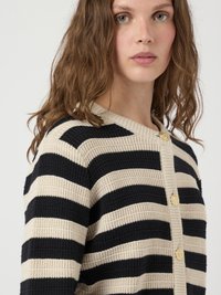 Cardigan a righe nei colori beige e navy, con texture a coste e quattro bottoni dorati. Presenta un collo rotondo e una vestibilità comoda.