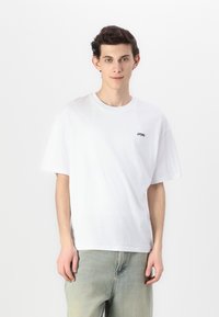 Tricou din bumbac alb, cu mâneci scurte și decolteu rotund. Are un mic logo negru "URFRESH" pe zona din stânga a pieptului.
