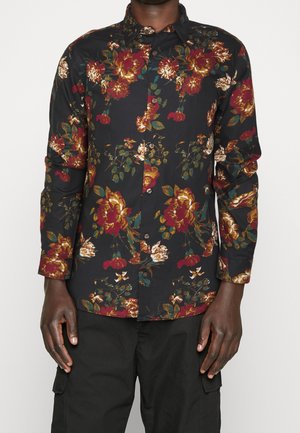 Camisa negra de manga larga con un patrón floral en rojo, dorado y verde. Cuenta con un cierre frontal de botones y un cuello clásico.