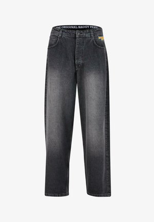 Lohkedega teksapüksid tuhmiks kulunud mustas teksariides, laia säärepikkuse, viie tasku ja vöökohaga, millele on trükitud "THE ORIGINAL BAGGY PANTS".