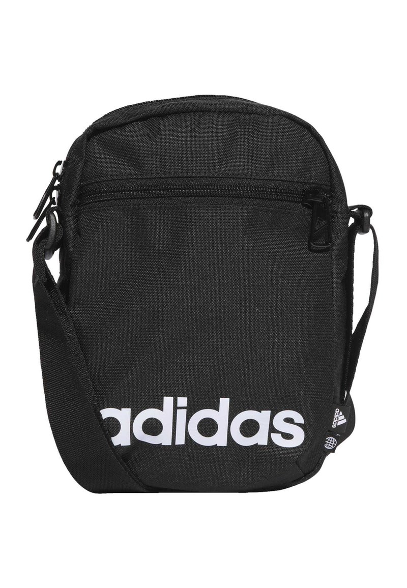 Bolsa cruzada de tela negra con cierre de cremallera, que presenta un gran logo blanco de "adidas" y una correa ajustable. Forma rectangular compacta.