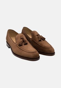 Braune WildlederSlipper mit Quasten, mit einer glatten, abgerundeten Spitze und einem niedrigen Absatz. Dekorative Stickereien entlang des oberen Randes.