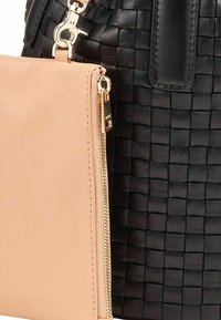Zwarte gevlochten handtas met een gladde blush tas; inclusief goudkleurige rits en sluiting hardware. Een textuur van het lichaam en contrasterende kleuren bepalen het ontwerp.