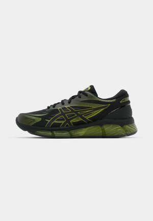 Zapatilla deportiva negra con detalles en verde, que cuenta con una parte superior texturizada, cierre con cordones y una suela acolchada para mayor soporte.