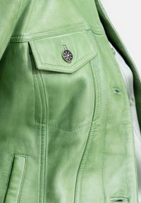 Groene leren jas met een gestructureerde afwerking, voorzien van een borstzak, zilveren knopen als accent en een getailleerd silhouet met zichtbare stiksels.