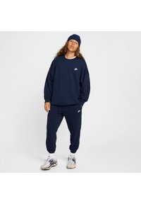 Tengerészkék pulóver és jogger nadrág pamut keverékből, kis fehér Nike logóval a mellen és a combon. Texturált kötött sapka.