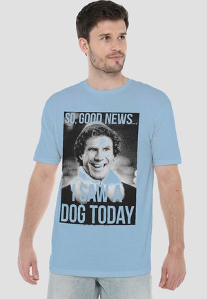 Man wearing light blue t-shirt with black and white graphic of a smiling person and text reading "So, good news... I saw a dog today."