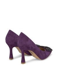 Scarpe con tacco alto in suede viola con punta affusolata e decorazioni nere sulla parte anteriore, dotate di tacco affusolato.