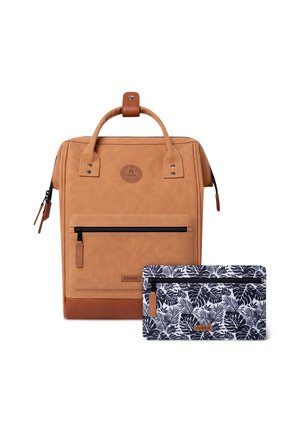 Zaino in pelle color cuoio con manico superiore e tasca frontale con zip accanto a un astuccio con zip dal motivo a foglie in bianco e nero.