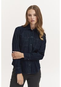Cămașă din denim închis, cu nasturi, guler, mâneci lungi și două buzunare la piept, având detalii de cusătură subtile și un croi relaxat.