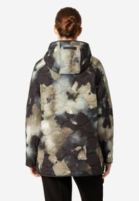 Chaqueta acolchada en tonos tierra apagados con patrones abstractos de acuarela. Presenta una capucha, un diseño acolchado y una textura de tela en contraste.