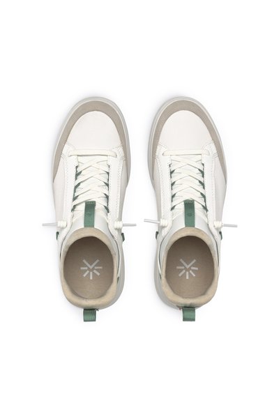 Baskets blanches et gris clair avec des textures en tissu et en daim, présentant des accents verts, des lacets ronds et un col rembourré.