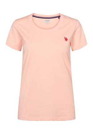 Heleroosa lühikeste varrukatega naiste puuvillane T-särk ümmarguse kaelusega ja vasakul rinnal väike punane tikitud U.S. Polo Assn. logo.