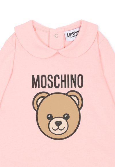 Top in cotone rosa con colletto arrotondato, testo stampato "MOSCHINO" e grafica di un orso in marrone e nero.