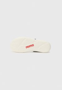 Biely gumový podrážka obuvi so štruktúrovanými vzormi a výrazným červeným logom "reima". Obsahuje krivky a rebrá pre lepšiu priľnavosť.