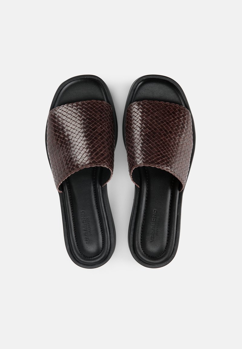Paar schwarze Slide-Sandalen mit breiten, strukturierten dunkelbraunen Riemen und gepolsterten Fußbetten, von oben auf weißem Hintergrund gezeigt.