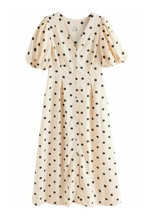 Robe à pois en tissu beige doux, avec des pois noirs, des manches bouffantes, un décolleté en V et une fermeture à boutons sur le devant. Silhouette en A.
