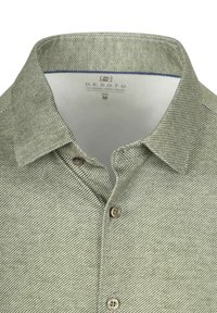 Kraagshirt in groen-wit visgraatpatroon, voorzien van knopen en een gladde stoftextuur. Gemedailleerd maat M.