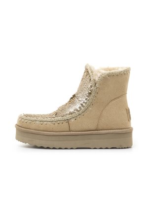 Botas de tobillo de ante beige con parte superior texturizada y decorada con brillantina, forro de piel sintética, costuras decorativas y suela gruesa y texturizada.
