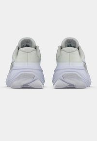 Ανοιχτό γκρι αθλητικά παπούτσια με υφασμάτινη επάνω επιφάνεια με υφή, επικαλυμμένο κολάρο και παχύ λευκό μεσαίο πέλμα. Ο εξωτερικός πάτος διαθέτει οριζόντιες αυλακώσεις για καλύτερη πρόσφυση.