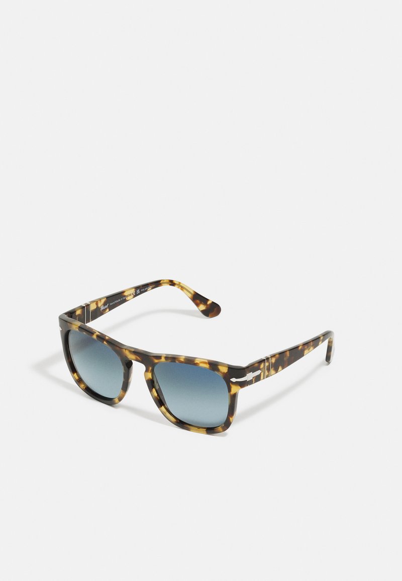 Ochelari de soare cu model țestoasă, dotati cu lentile cu gradient albastru. Rama de formă pătrată, din material acetate texturizat, cu accente metalice pe brațe.