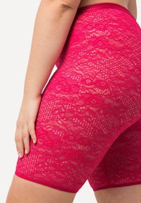 Helderroze kanten short met een bloemenpatroon, gladde textuur en een aansluitend ontwerp. De tailleband is in een bijpassende effen kleur.