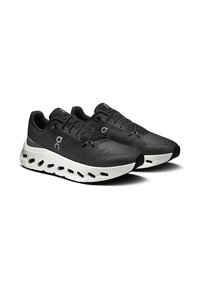 Scarpe da ginnastica nere con tomaia in mesh traspirante e suola bianca con dettagli intagliati. Chiusura con lacci e collare imbottito per maggiore comfort.