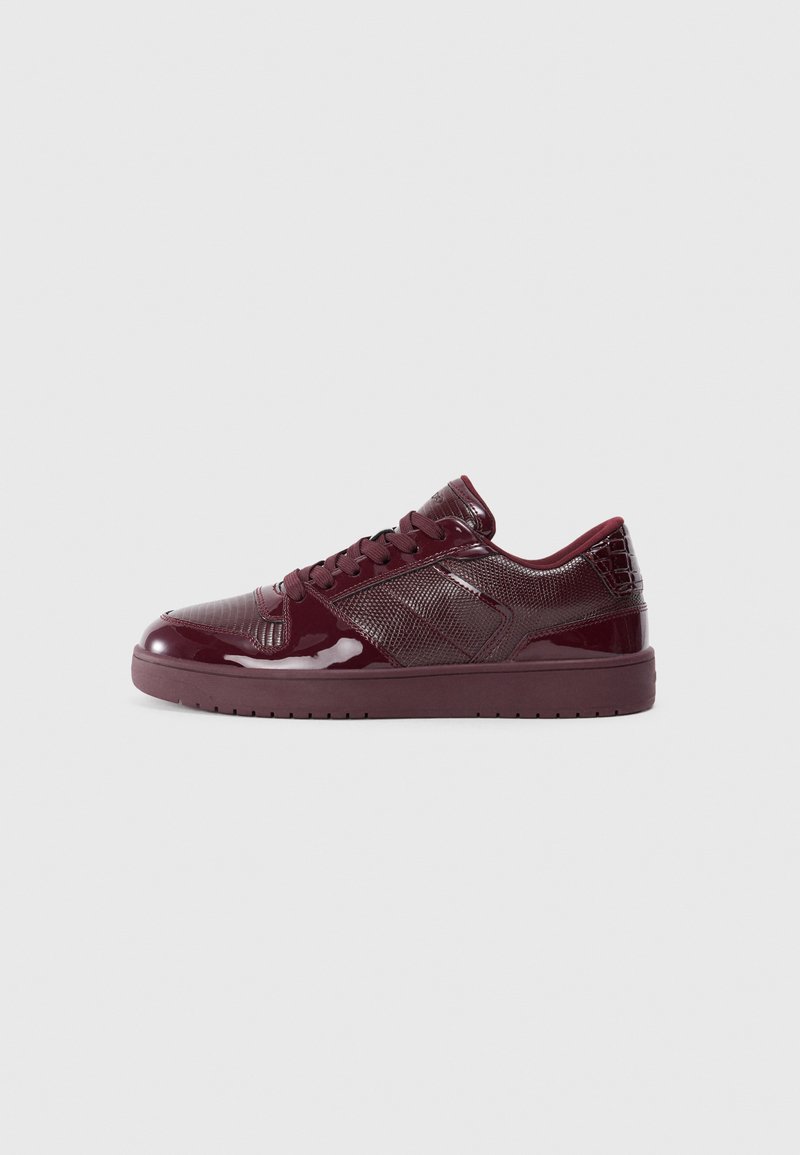 Sneaker burgund cu piele patenta lucioasa si panouri din plasa texturata. Dispune de un design low-top, varf rotund si talpa din cauciuc.