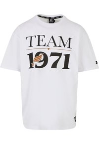 Biała bawełniana koszulka z czarnym i brązowym graficznym nadrukiem z napisem „TEAM 1971” oraz skrzydlatym emblematem. Krótkie rękawy i okrągły dekolt.