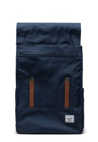 Navy blue roll-top backpack made of durable fabric, featuring a front zip pocket, brown leather accents, and a white logo patch.