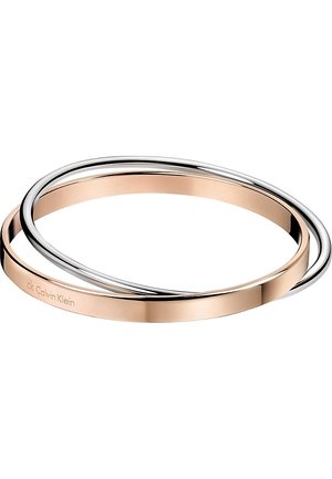 To sammenflettede tynde armbøjler, den ene i rosaguld med Calvin Klein-gravering og den anden skinnende sølv, på en hvid baggrund.
