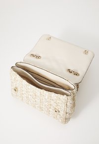 Borsa intrecciata beige e crema con un'esterno texturizzato, interno in morbida pelle, dettagli in oro e una chiusura magnetica singola.