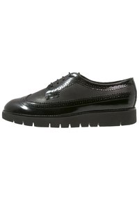 Chaussure en cuir verni noir avec un bout arrondi, des détails brogues et une semelle plateforme noire épaisse. Conçue avec cinq œillets pour les lacets.