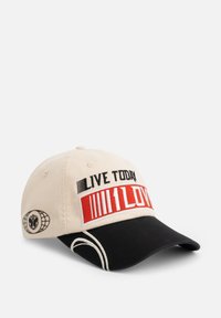 Cap aus beigem Stoff mit einer schwarzen Schirm. Verfügt über rote und schwarze gestickte Schriftzüge: "LEBE HEUTE" und "1LIEBE." Beinhaltet ein Logo-Detail an der Seite.