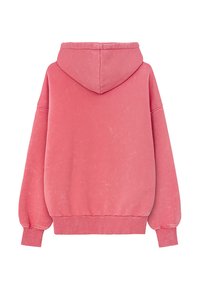 Przytulny różowy hoodie w oversize'owym fasonie, wykonany z miękkiego materiału, z kapturem na sznurku, prążkowanymi mankietami i dołem, o lekko teksturowanym wykończeniu.