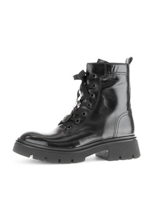 Bottines en cuir verni noir avec un système de laçage, semelle en caoutchouc épaisse et œillets en métal. Présentent une languette à l'arrière.