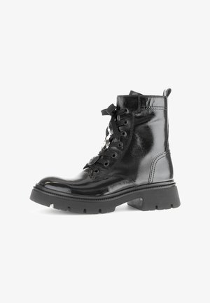 Black patent leather ankle boots with a lace-up design, chunky rubber sole, and metal eyelets. Features a pull tab at the back.