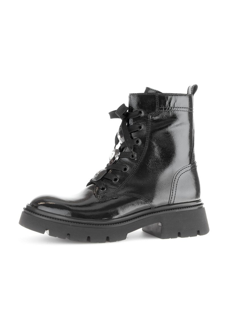 Black patent leather ankle boots with a lace-up design, chunky rubber sole, and metal eyelets. Features a pull tab at the back.