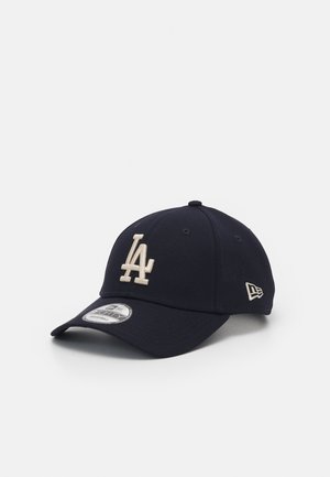 Casquette de baseball bleu marine avec logo "LA" blanc à l'avant, logo de la marque sur le côté, visière courbée et bride réglable.