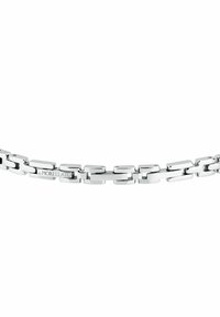 Bracciale in argento con maglie rettangolari allungate, finitura lucida e placca con logo. Texture liscia con superficie riflettente.