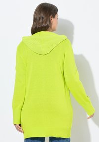 Cardigan lungo verde lime con cappuccio texturizzato, polsini e orlo a coste, e spacchi laterali, realizzato in morbido materiale a maglia.