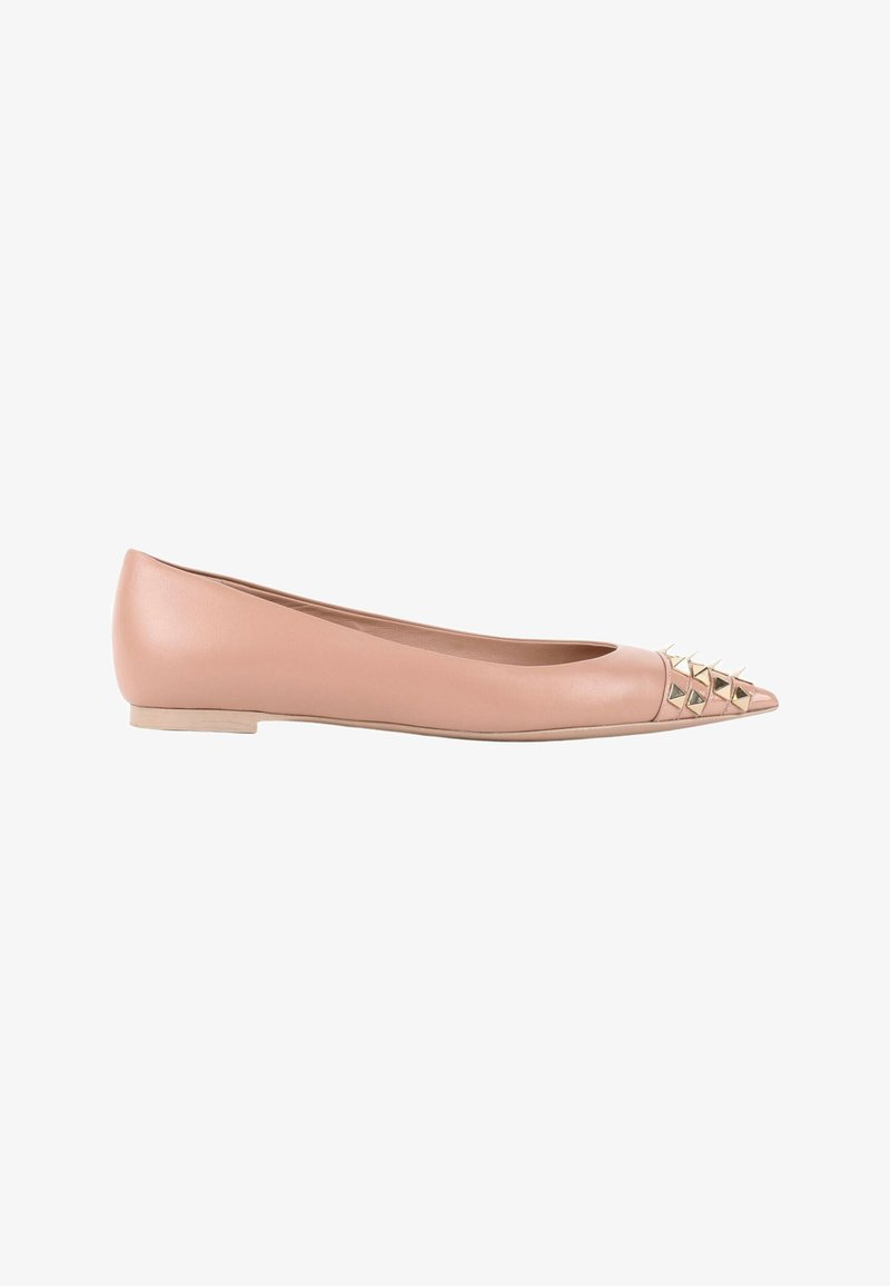 Chaussure plate à bout pointu rose clair avec de petits clous pyramides dorés décorant la zone des orteils, vue de côté.