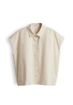 Blusa beige a maniche corte con colletto appuntito, vestibilità ampia e cinque bottoni frontali, mostrata su sfondo bianco.