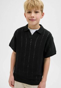 Pull noir à manches courtes avec un col en V, présentant un motif tricoté texturé avec des découpes verticales et un ourlet côtelé.