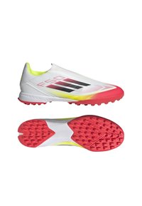 Weiße Sportschuhe mit einer strukturierten Oberseite, schwarzen und roten Akzenten sowie einer pinkfarbenen Gummisohle, die mit multidirektionalen Stollen für besseren Halt ausgestattet ist.