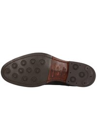 Semelle en cuir brun avec des grips en caoutchouc circulaires et des coutures ; comprend des détails en relief, taille étiquetée 41, sections lisses et texturées.